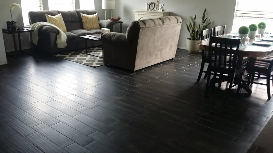 Dark plank flooring connecting living and dining spaces.