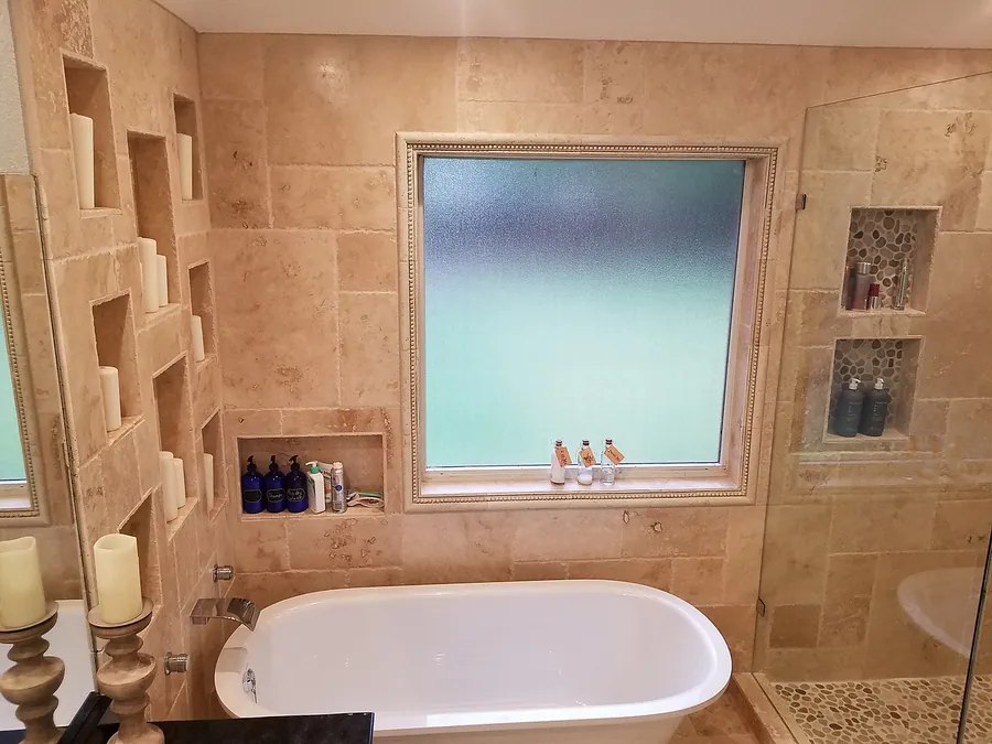 Natural stone and a freestanding bathtub with built-in niches.