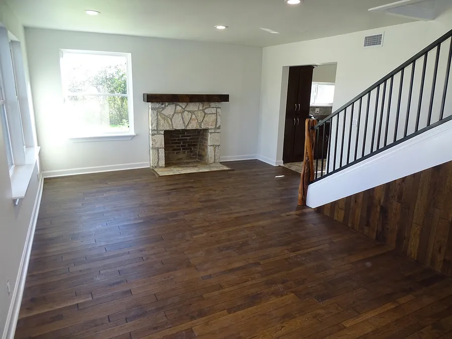 Updated living room with dark wood flooring and a stairway