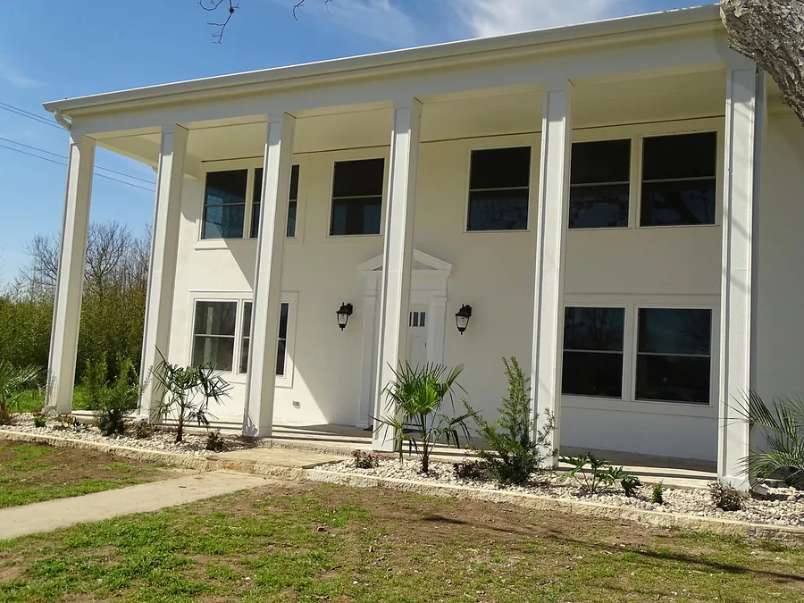 A spacious home exterior with traditional columns and finishes.