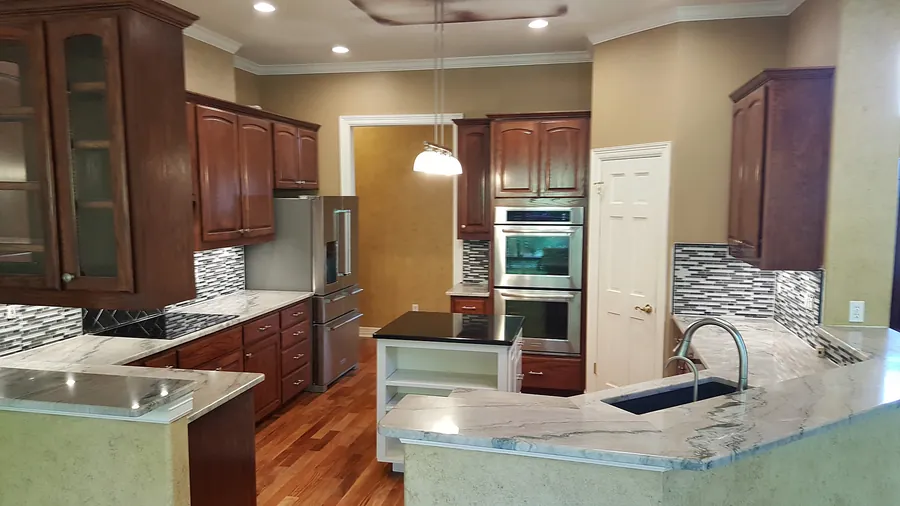 Warm wood and pale stone in an open kitchen layout.