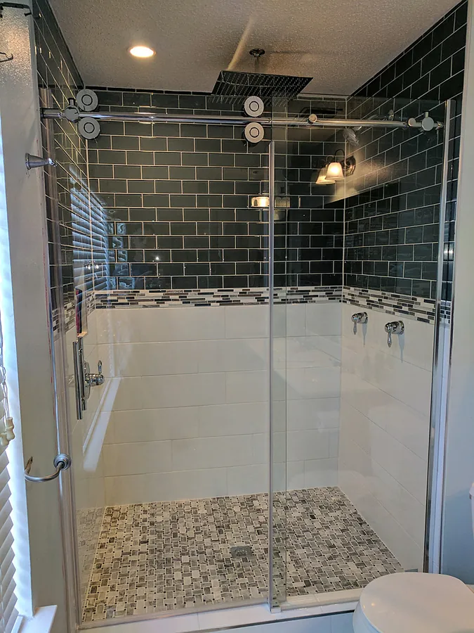 An enclosed shower with dramatic deep-toned tile.