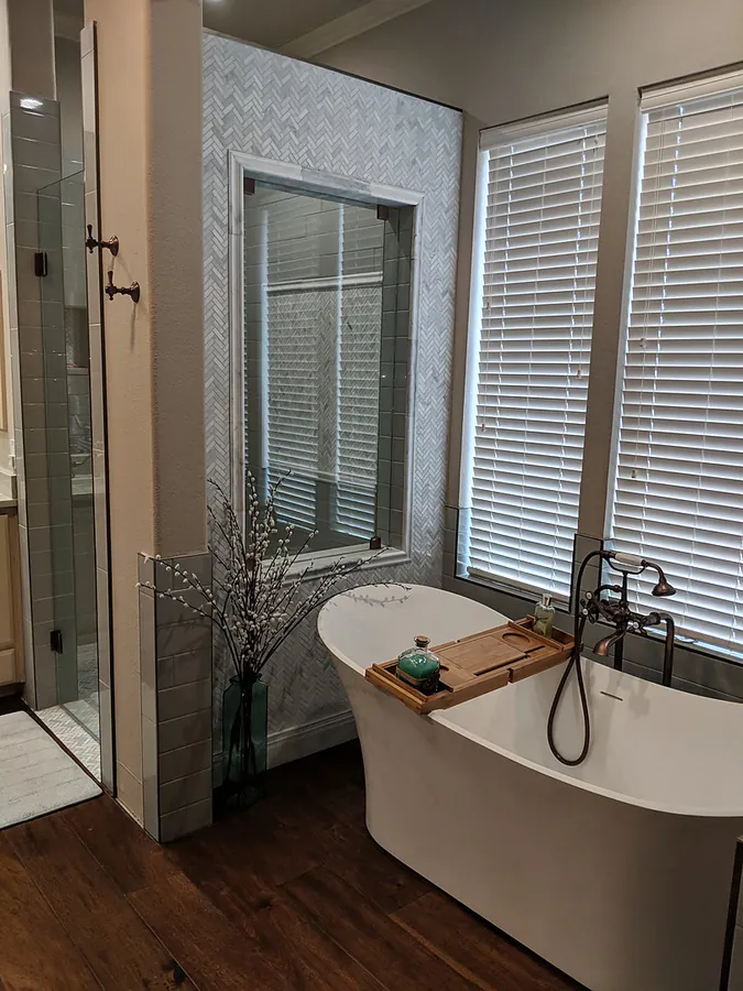 A soaking tub and tiled shower sharing a bright space.