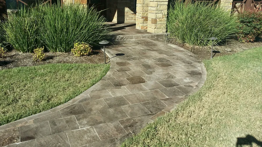 Outdoor stone paving with curved landscaping edges.