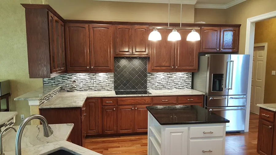 Rich cabinetry, contrasting island and tiled backsplash.