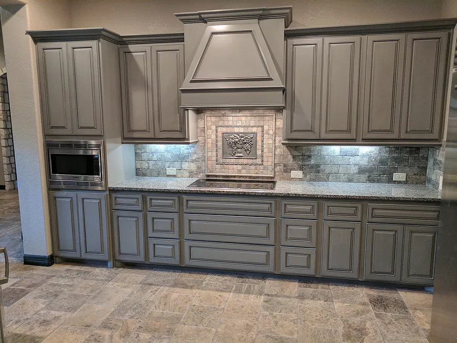 A custom-look kitchen wall with detailed cabinetry and backsplash.