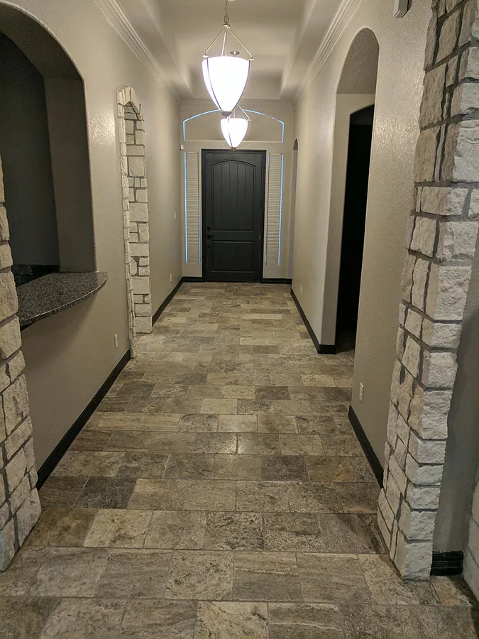 A stone-tiled interior hallway and arched doorway details.
