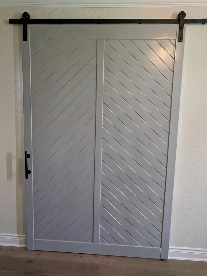 Chevron-panel doors with dark metal track hardware.