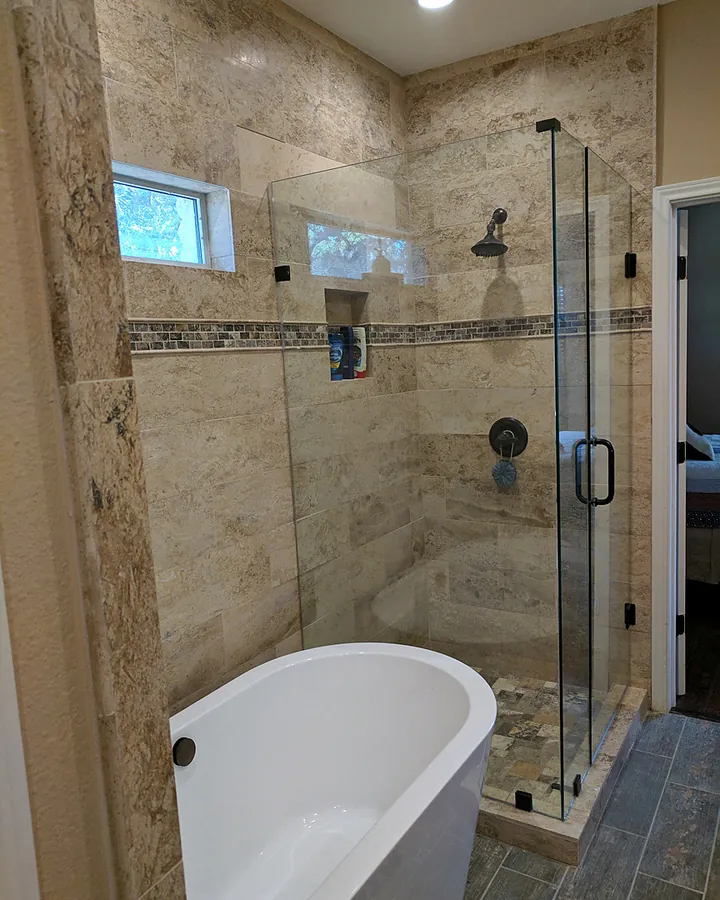 Stone tile, soaking tub and glass-enclosed shower.