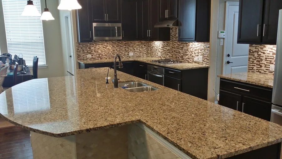 A large natural-pattern countertop with dark cabinetry.
